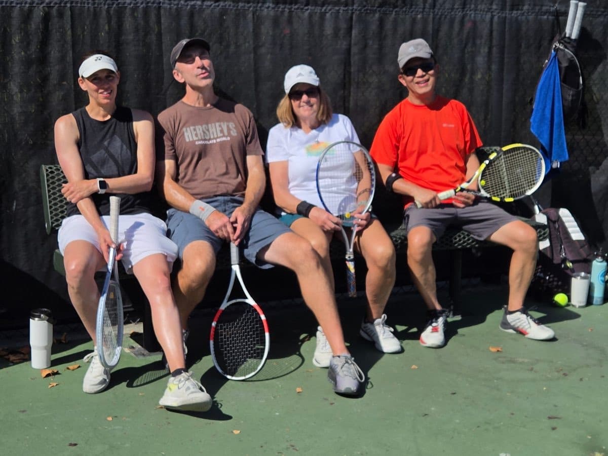 Four players relaxing on the bench between matches