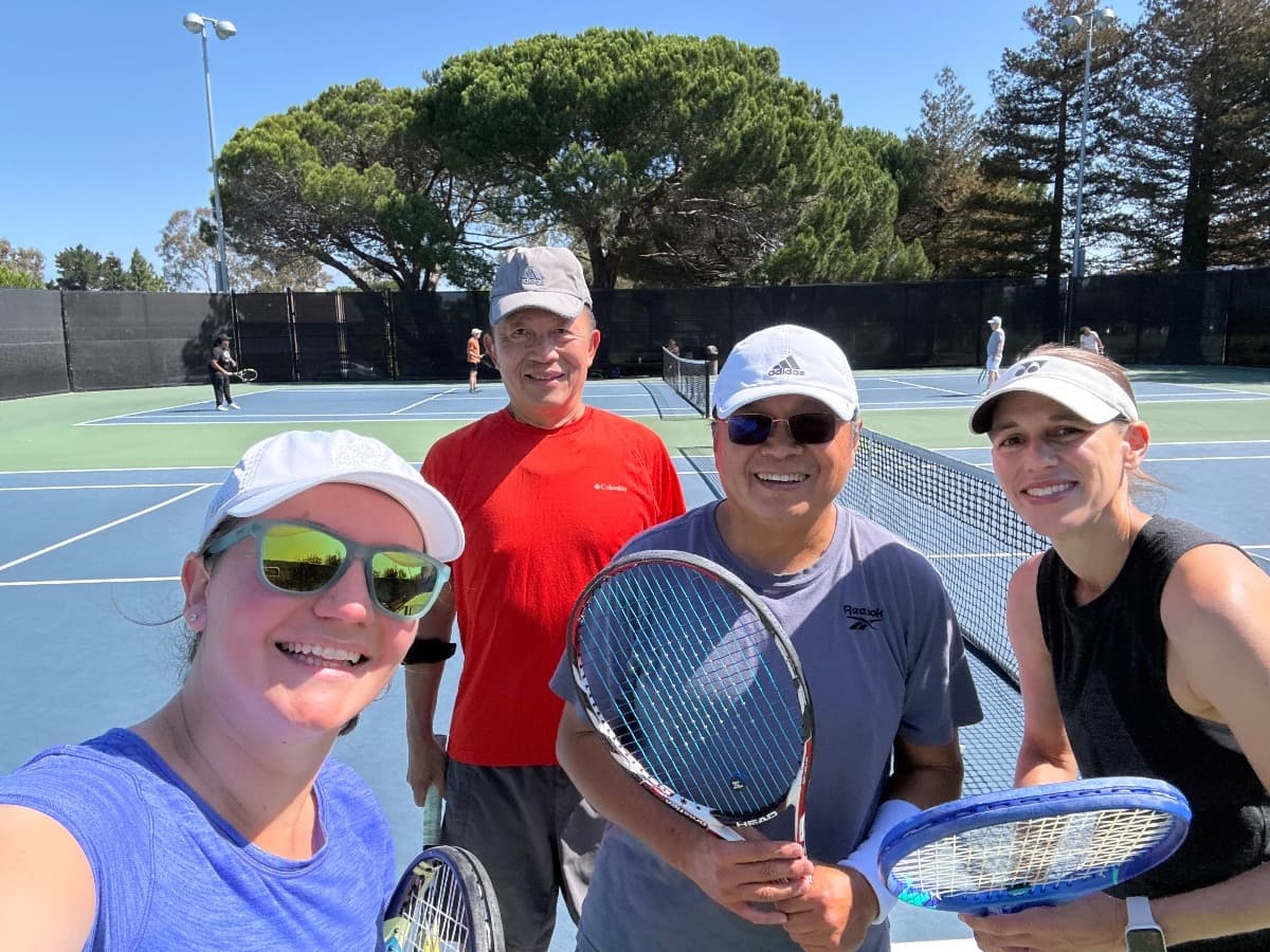 Four players smiling in a selfie on court
