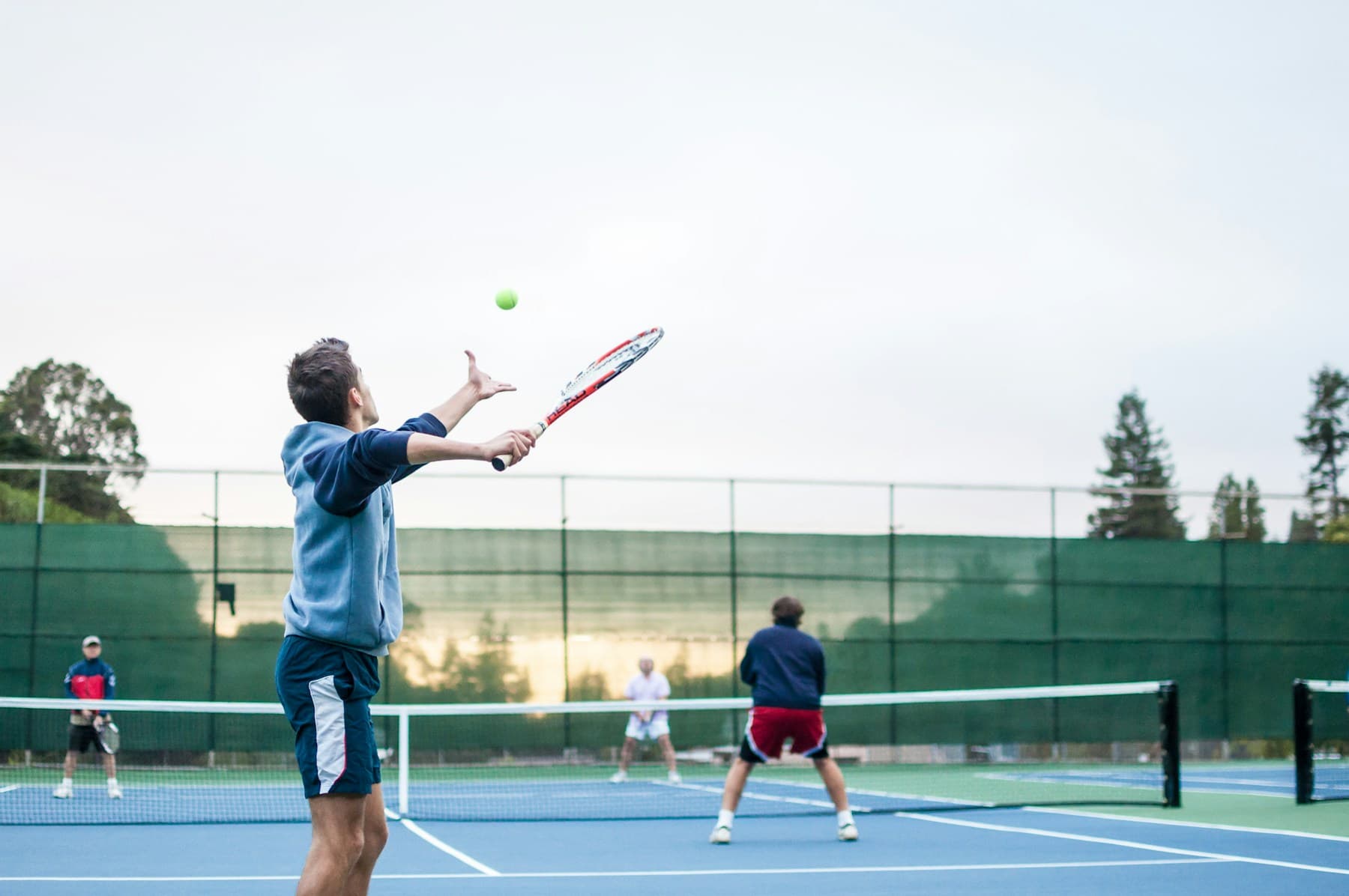 Friends playing doubles at an outdoor club