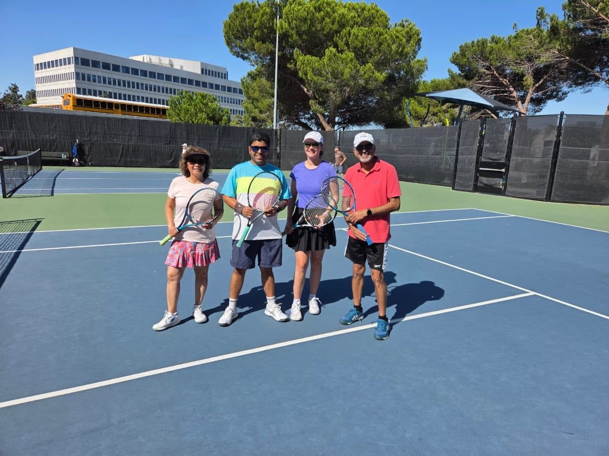 Four players standing together on a blue court