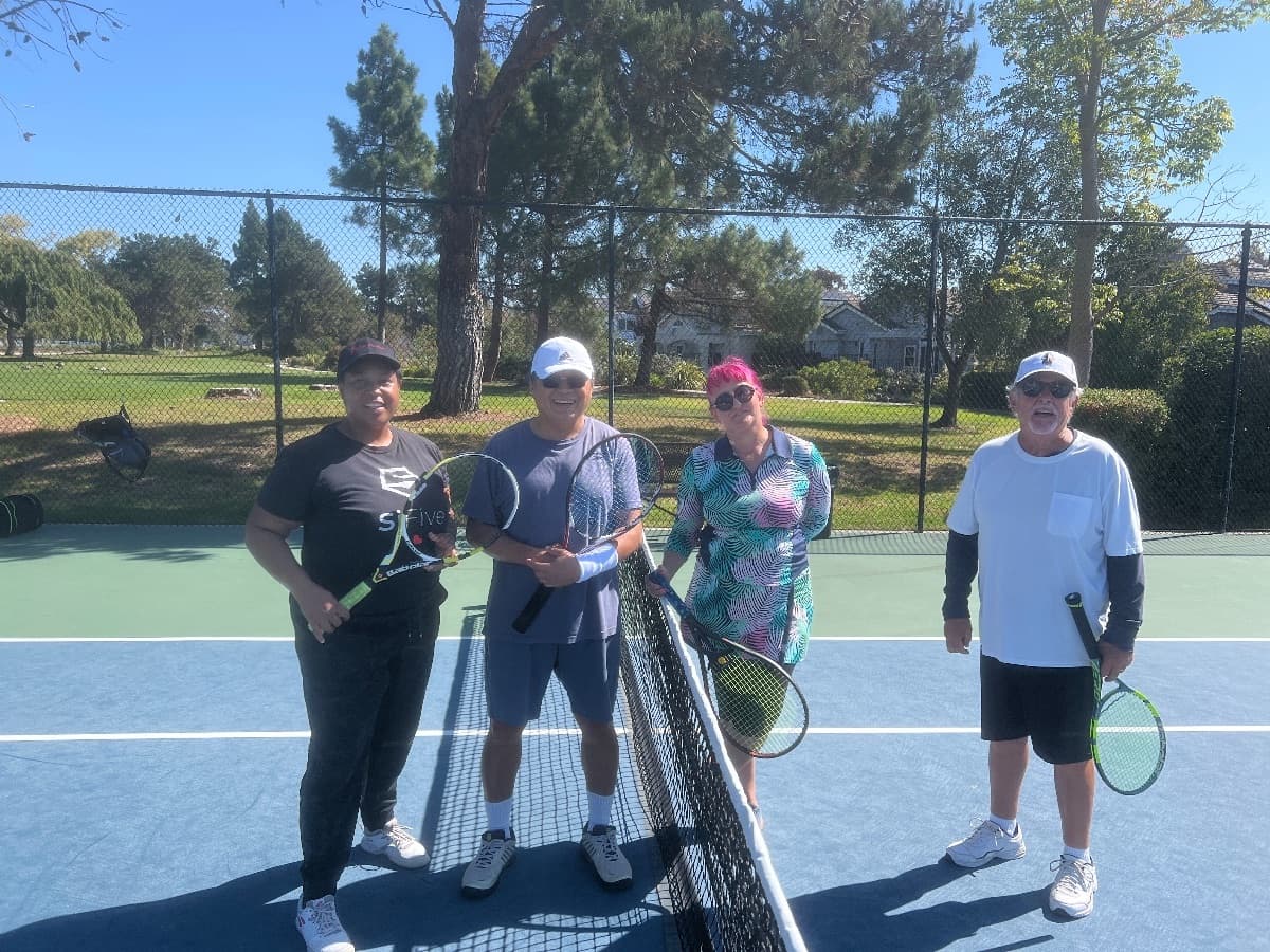 A foursome meeting at the net before their match