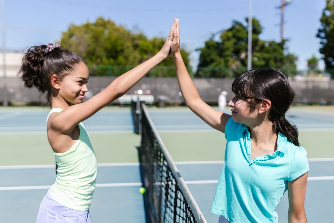 Two players sharing a high five over the net