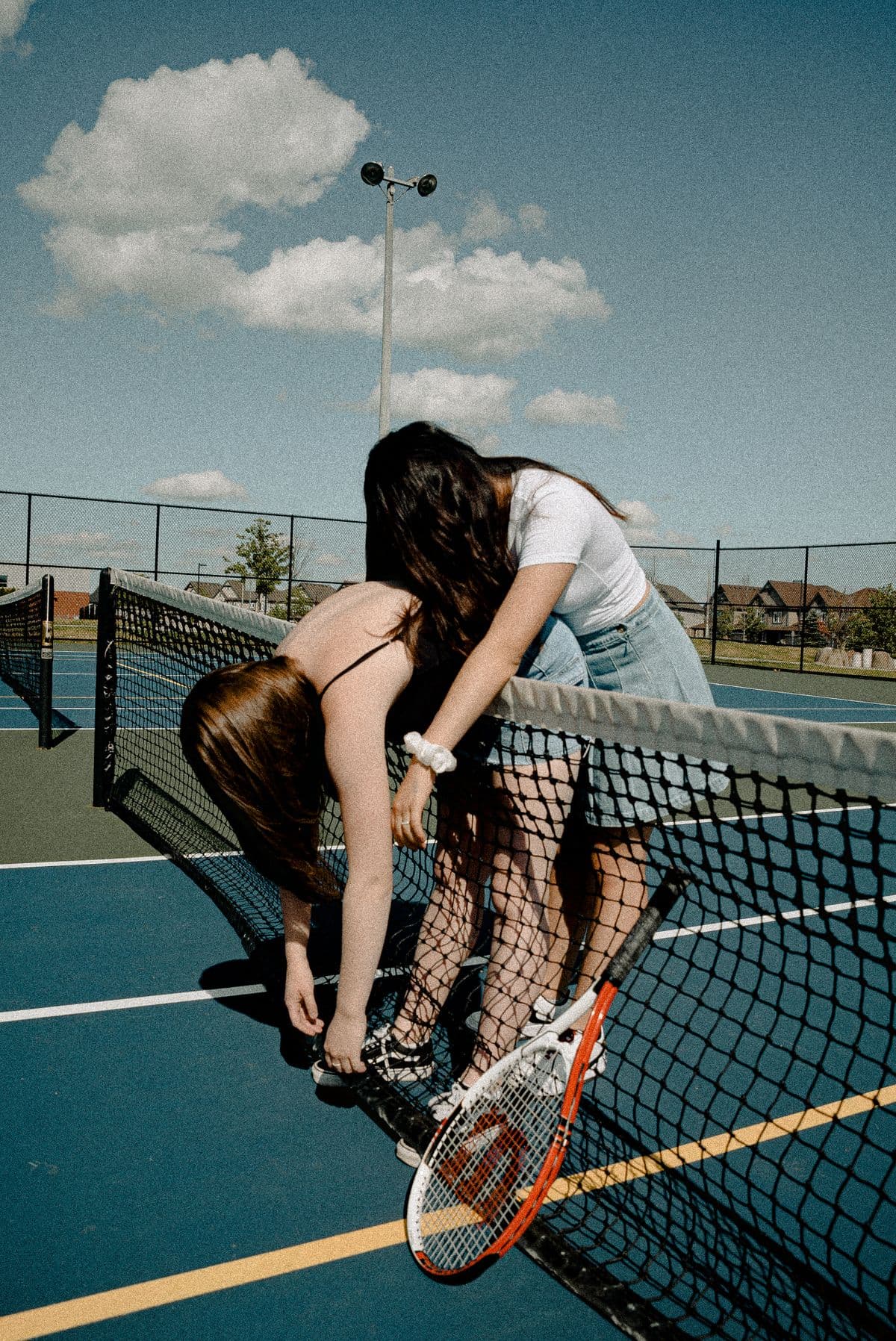 Two friends laughing together over the net